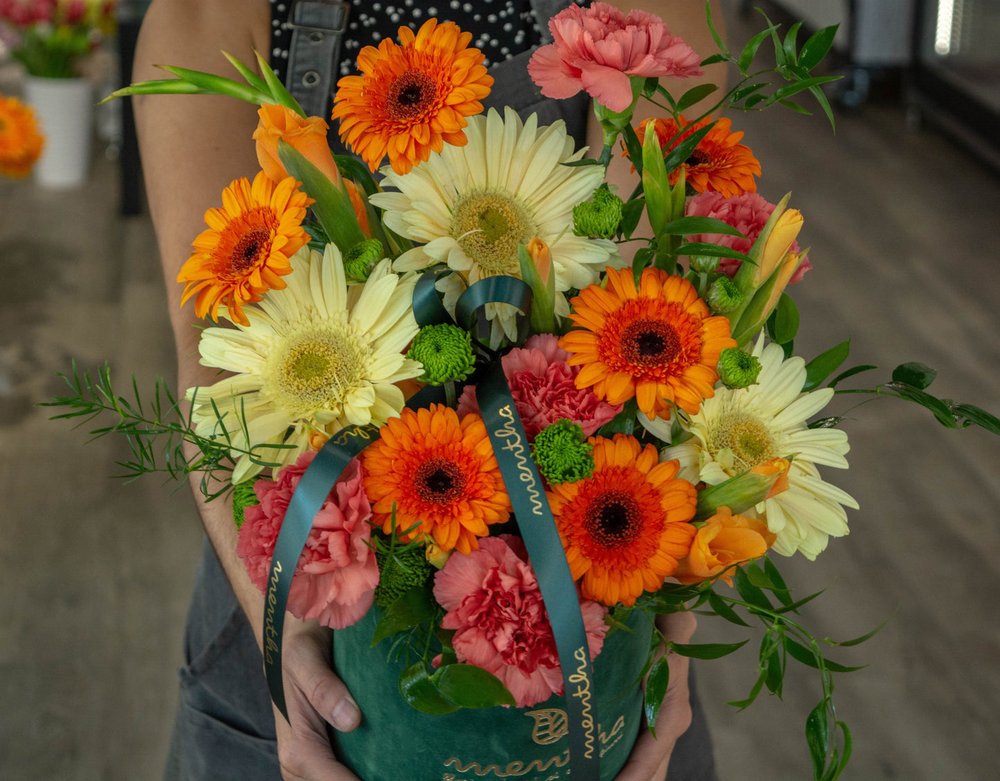 Compoziție florală vibrantă într-o cutie de catifea verde, perfectă pentru orice ocazie specială
