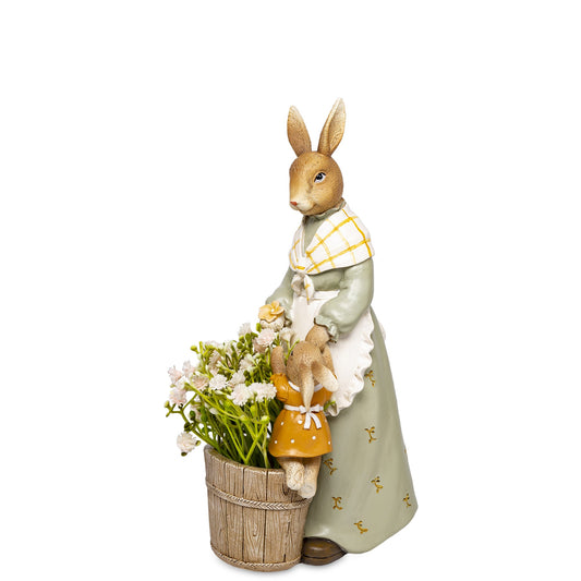 Figurină decorativă mama iepuraș cu coș de flori, simbol al familiei, primăverii și grijii materne. Este perfectă pentru decor de Paște sau primăvară și aduce un aer cald și vesel în casă. Ideală ca dar pentru familie, copii sau cadouri sezoniere.