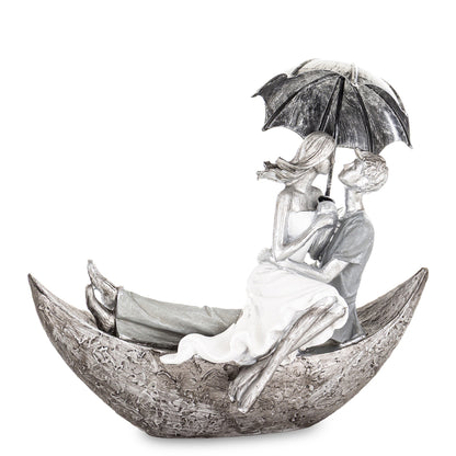 Figurină decorativă cuplu în barcă sub umbrelă, simbol al călătoriei în doi, al iubirii și echilibrului emoțional. Este o piesă poetică și elegantă pentru decorul casei sau dormitor. Ideală ca dar romantic pentru aniversări, nuntă, casă nouă sau momente speciale în cuplu.