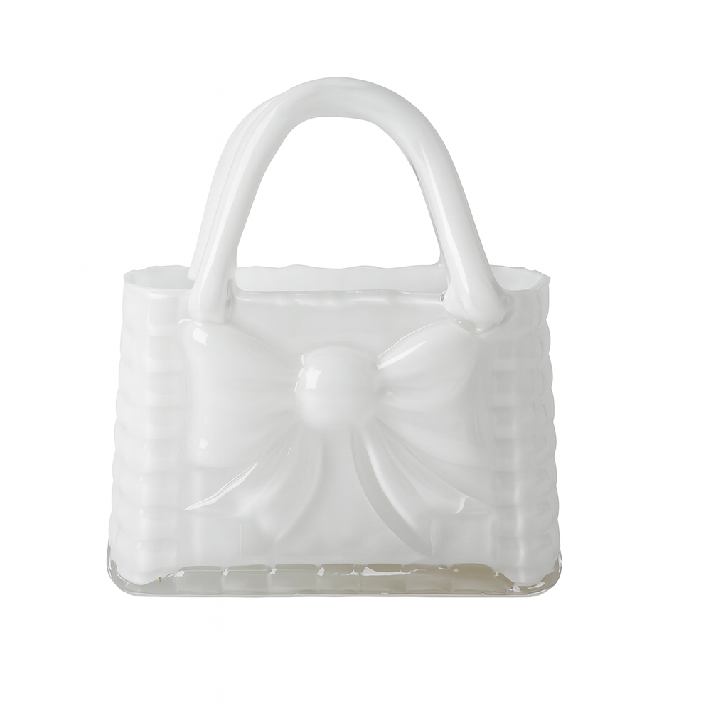 Vază decorativă din sticlă albă în formă de poșetă, concepută pentru interioare luminoase și elegante. Designul său curat adaugă rafinament și simplitate, fiind ideală pentru decor minimalist sau modern. Se potrivește perfect cu flori delicate și este o alegere excelentă pentru cadouri de casă nouă sau decoruri premium.