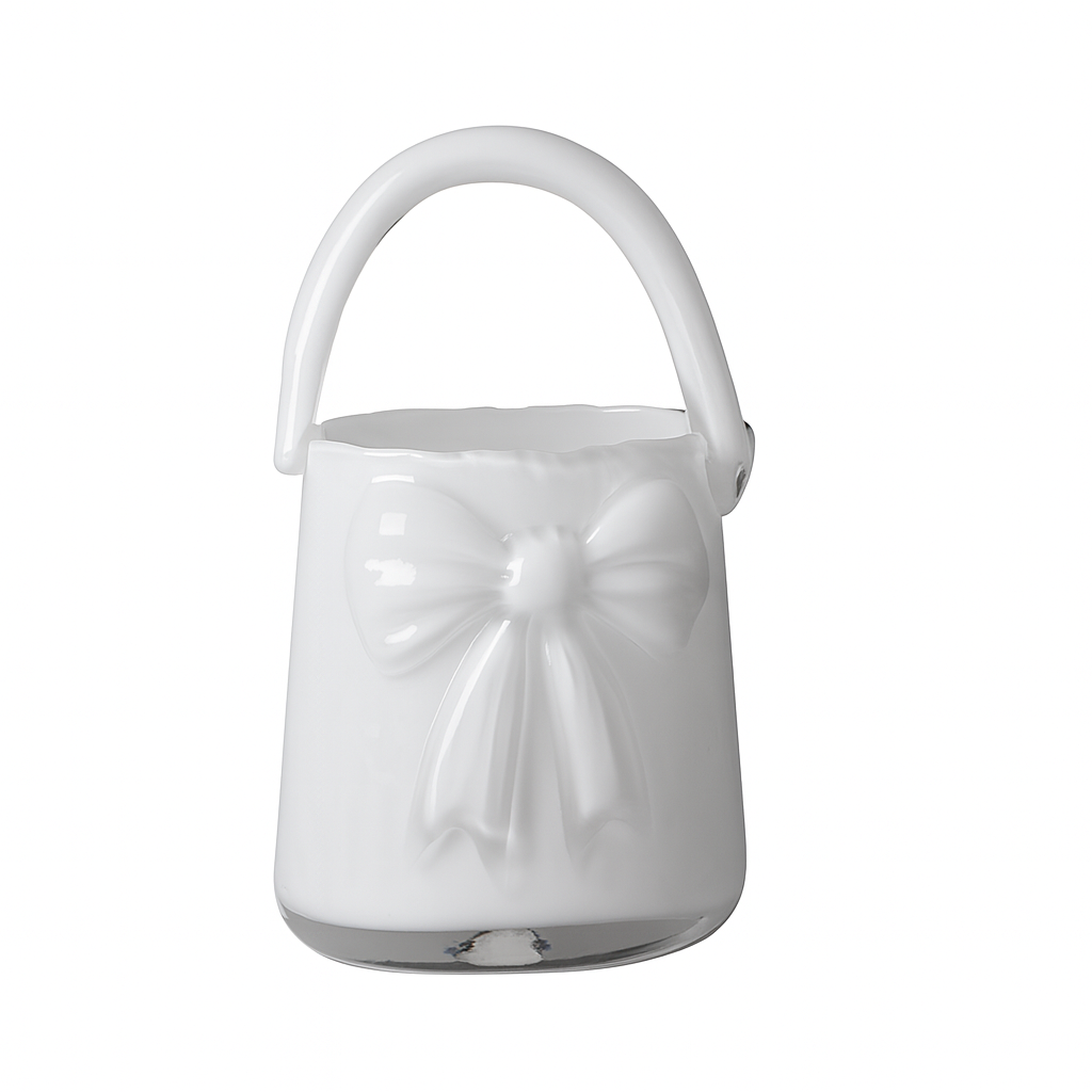 Vază decorativă din sticlă albă în formă de poșetă, concepută pentru interioare luminoase și elegante. Designul său curat adaugă rafinament și simplitate, fiind ideală pentru decor minimalist sau modern. Se potrivește perfect cu flori delicate și este o alegere excelentă pentru cadouri de casă nouă sau decoruri premium.