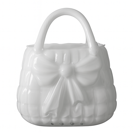 Vază decorativă din sticlă albă în formă de poșetă, concepută pentru interioare luminoase și elegante. Designul său curat adaugă rafinament și simplitate, fiind ideală pentru decor minimalist sau modern. Se potrivește perfect cu flori delicate și este o alegere excelentă pentru cadouri de casă nouă sau decoruri premium.