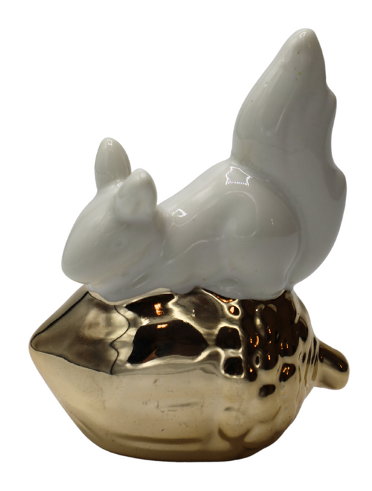 Mini figurină decorativă veveriță așezată pe ghindă cu finisaj alb și detalii aurii elegante, creată pentru a aduce un plus de rafinament și căldură oricărui decor interior. Designul delicat inspirat din natură se integrează perfect în decoruri moderne, glam sau clasice și oferă un accent decorativ sofisticat pentru living, birou sau rafturi decorative. Simbol al hărniciei, energiei și prosperității, această figurină este ideală pentru cadouri de casă nouă,