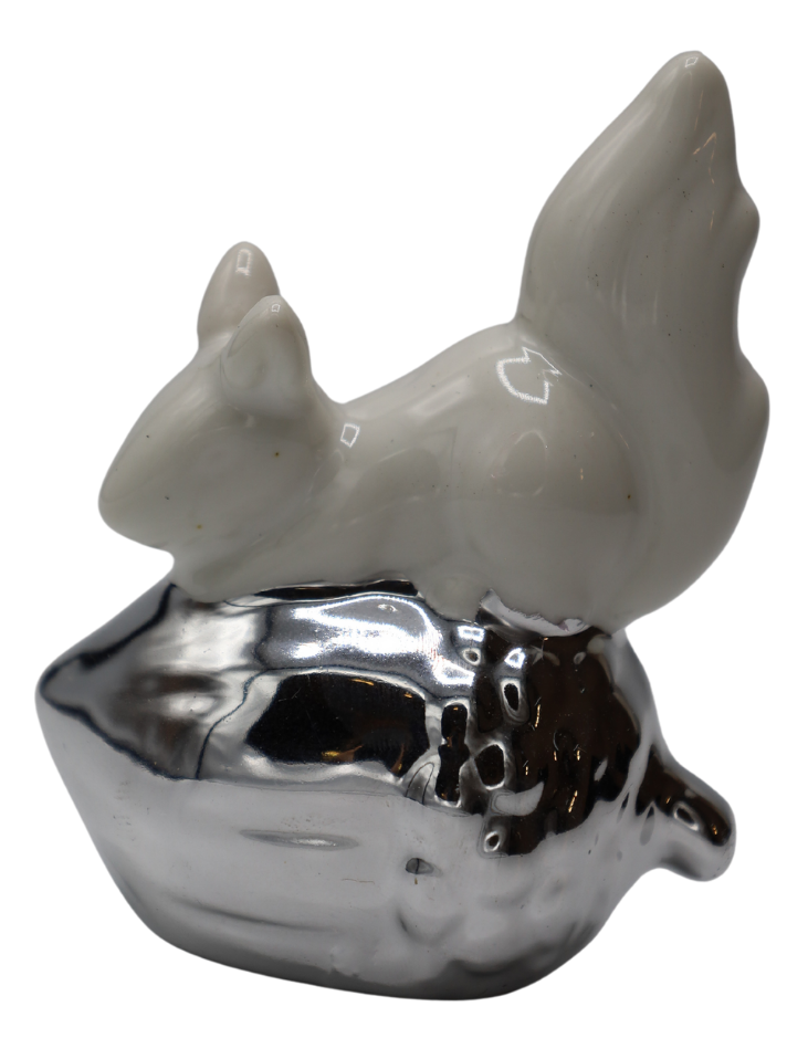 Mini figurină decorativă veveriță pe ghindă realizată în nuanțe alb și argintiu, ideală pentru decoruri elegante și rafinate. Aspectul său delicat și finisajele premium completează armonios spațiile moderne sau clasice și adaugă un accent decorativ luminos și sofisticat în living, dormitor sau birou. Este o alegere excelentă pentru persoanele care apreciază decorurile inspirate din natură și pentru cadouri simbolice oferite la aniversări, sărbători sau casă nouă.