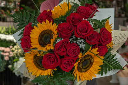 Detaliu buchet cu trandafiri roșii și floarea soarelui - aranjament floral vibrant - livrare în Reșița