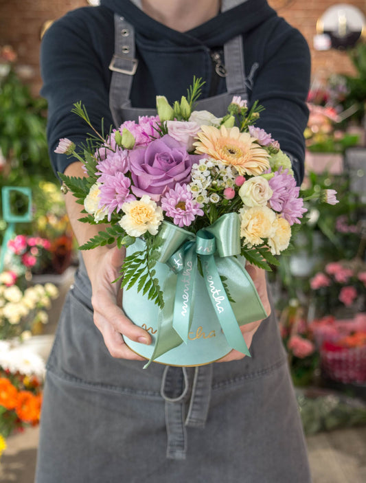 Cutie elegantă cu explozie de culori turcoaz: flori mov pastel și asortate, cu livrare GRATUITĂ în Resita.