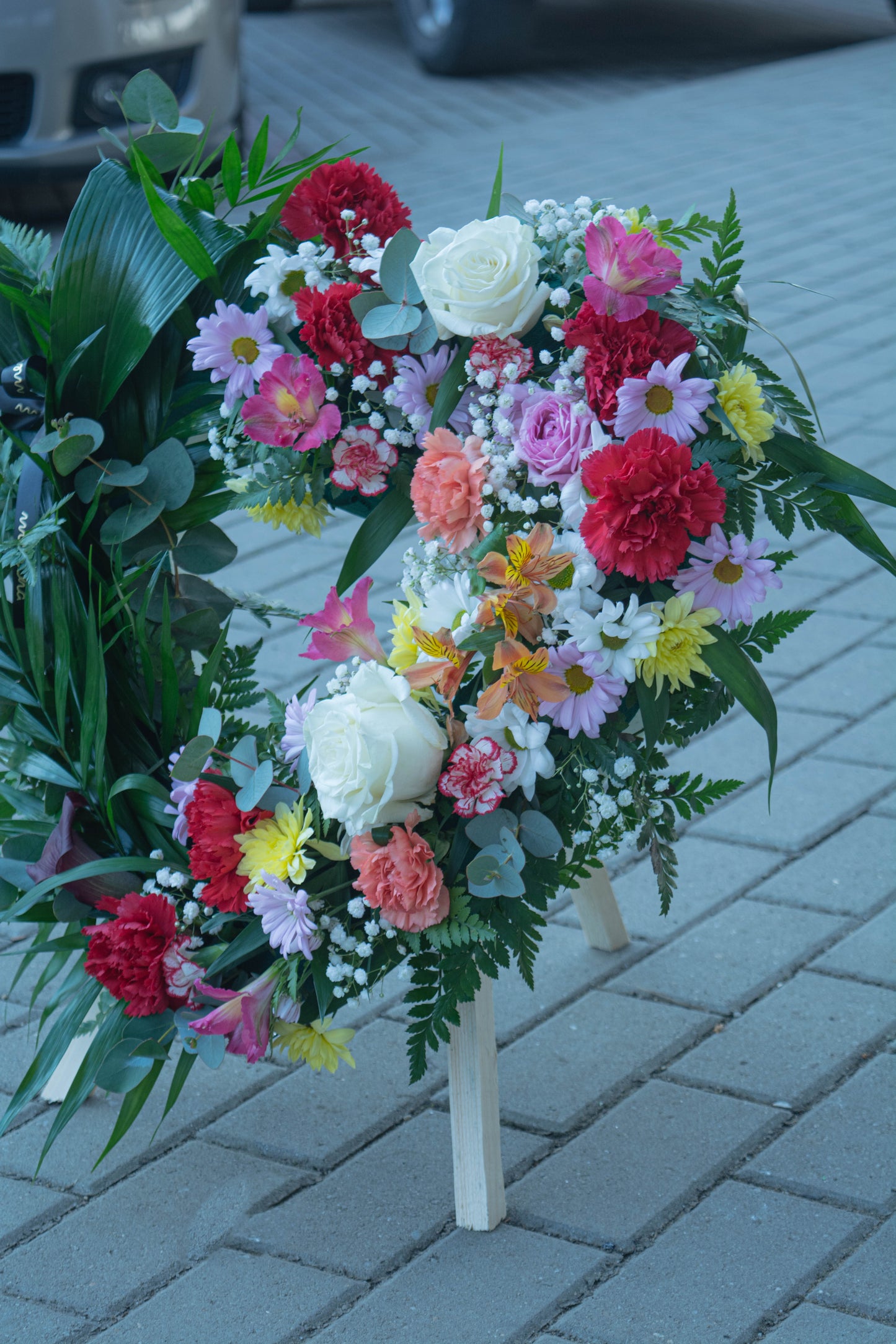 Detaliu al coroanei funerare inimă cu flori colorate și verdeață - livrare în Reșița