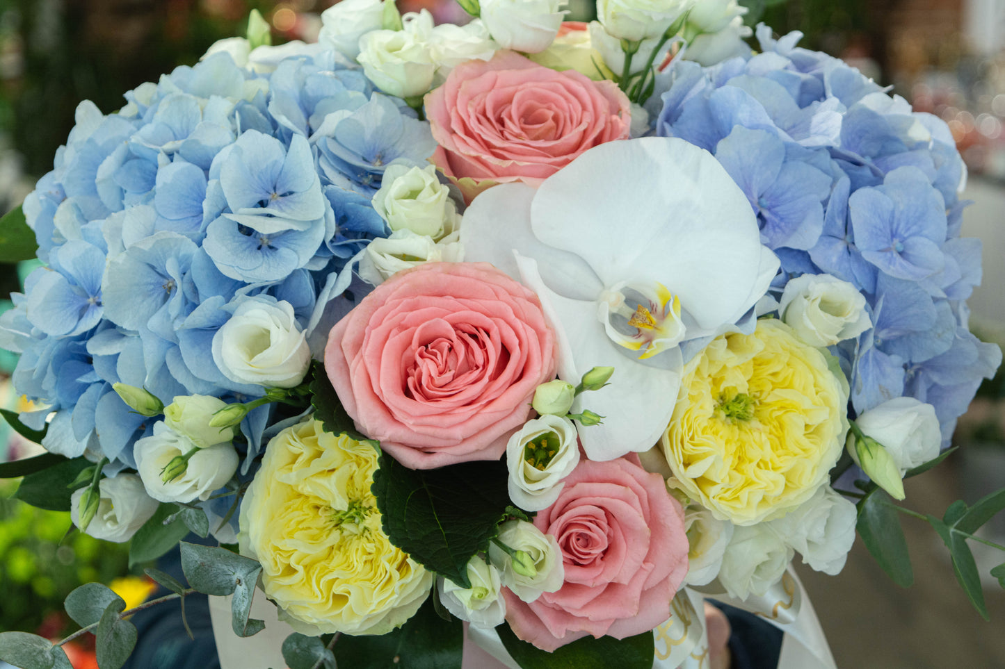 Aranjament floral pastel de vară cu hortensie albastră, trandafiri galbeni și roz și phalaenopsis alb - livrare flori în Reșița