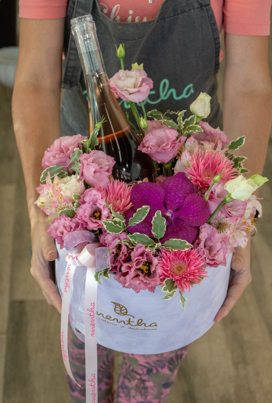 Sticlă de vin de la Crama Gabai, alături de aranjamentul floral delicat, o combinație perfectă pentru o seară romantică