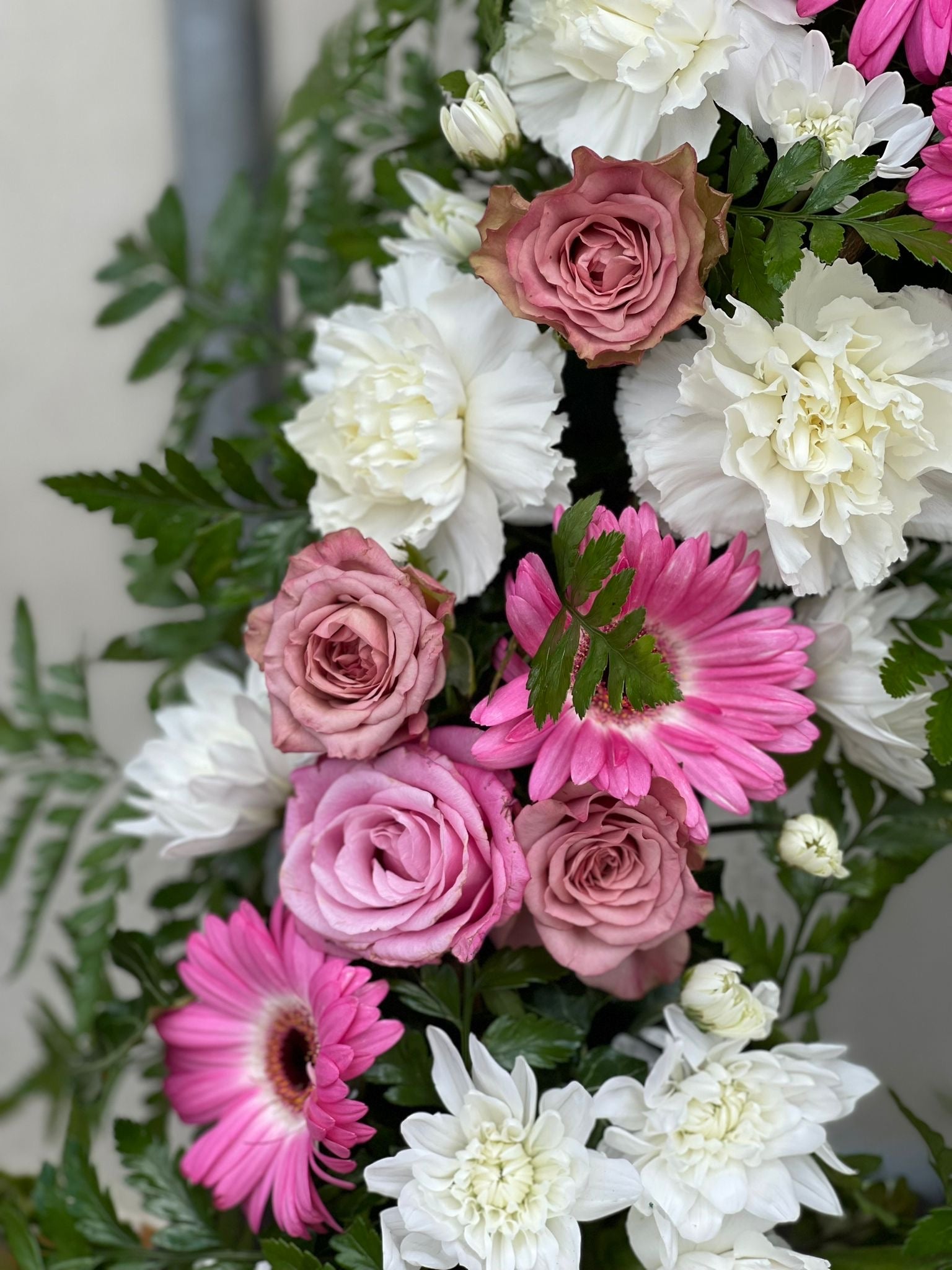 Coroană funerară cu trandafiri mov pal, crizanteme albe și gerbera roz - coroane funerare Reșița
